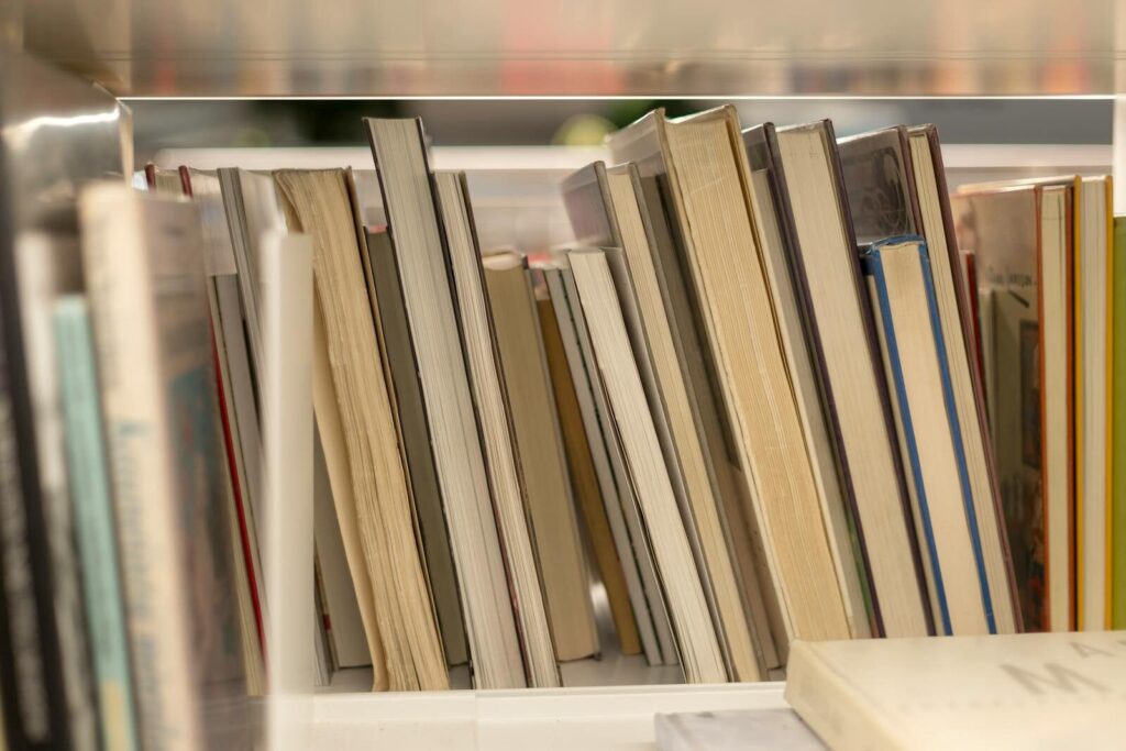 A close-up view of various books stacked vertically on a library shelf.